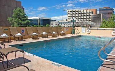 Refreshing outdoor pool surrounded by sunbeds at DoubleTree By Hilton Albuquerque.