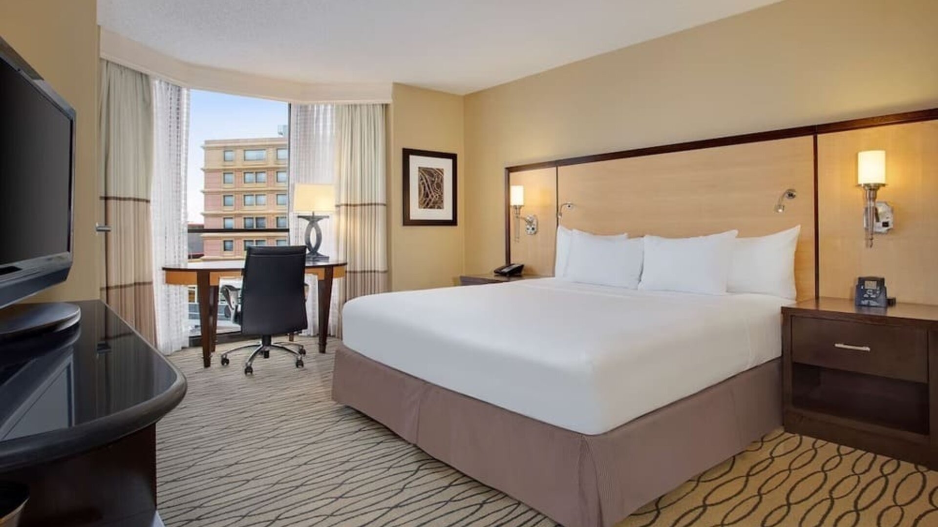 Spacious king room with TV and work area ideal for working remotely at Hilton Rosemont/Chicago O'Hare.