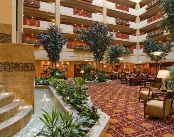 Spacious lobby and coworking lounge with natural light at Embassy Suites By Hilton Hampton Convention Center.