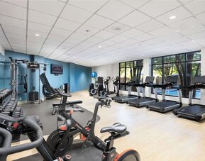 Well-equipped fitness center with a view of the pool at Doubletree By Hilton Houston Medical Center Hotel & Suites.