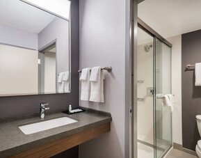 Private guest bathroom with shower and free toiletries at Sonesta Select San Jose Airport.