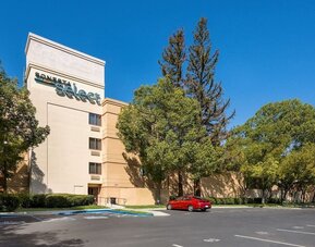Hotel exterior and parking area at Sonesta Select San Jose Airport.