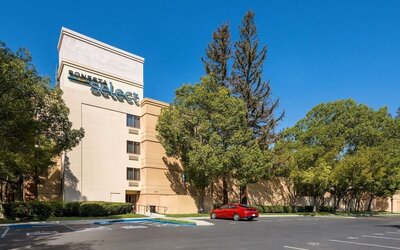 Hotel exterior and parking area at Sonesta Select San Jose Airport.