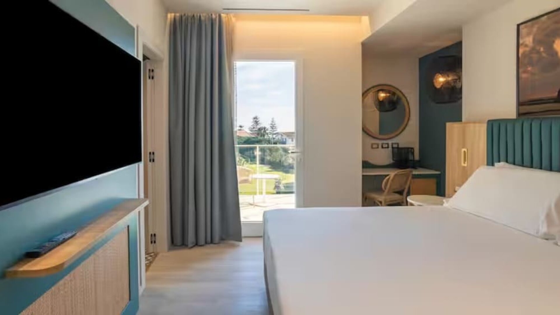 King bed with TV at Terradamari Resort & Spa Marina Di Modica.