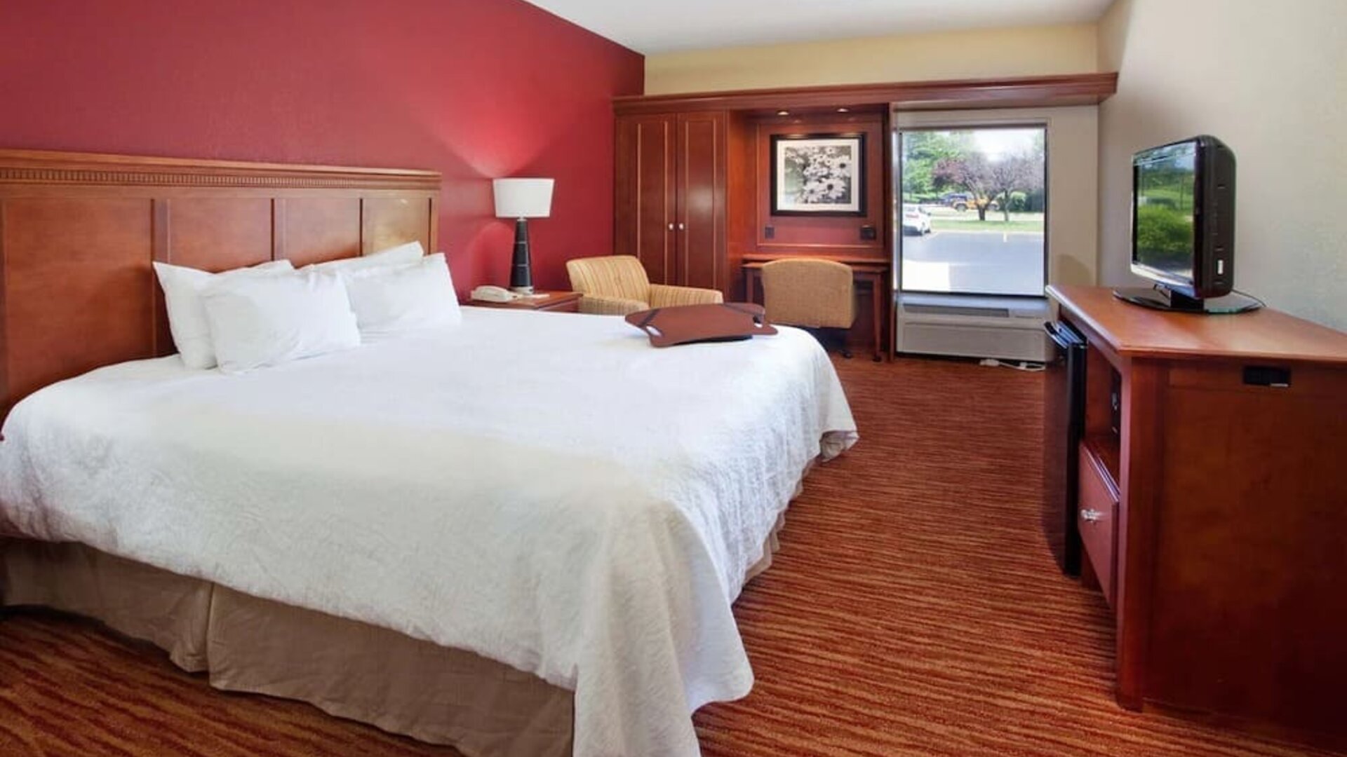 King room with TV screen, work desk and sofa at Hampton Inn Columbus-East.