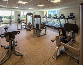 Fitness center with natural light at Hilton Dallas/ Plano Granite Park.