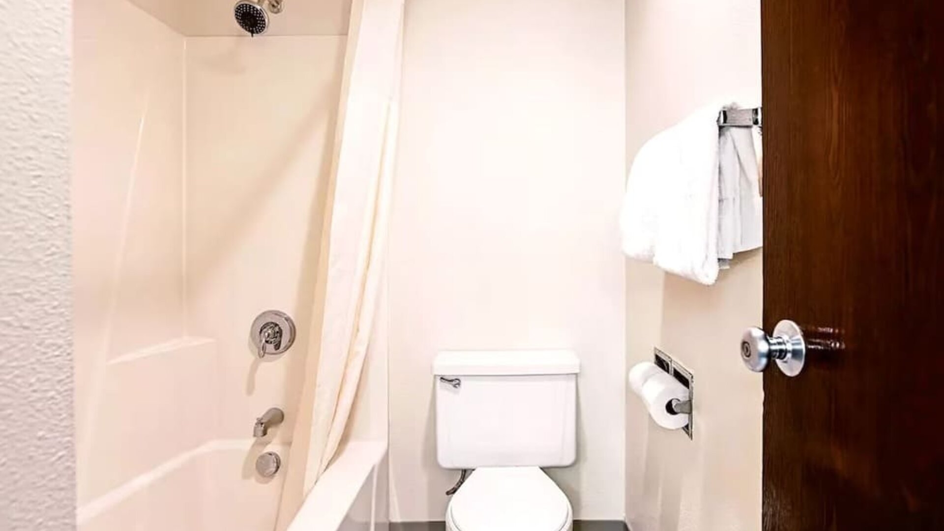 Private guest bathroom with combined shower and tub at Hotel Inn Milwaukee.
