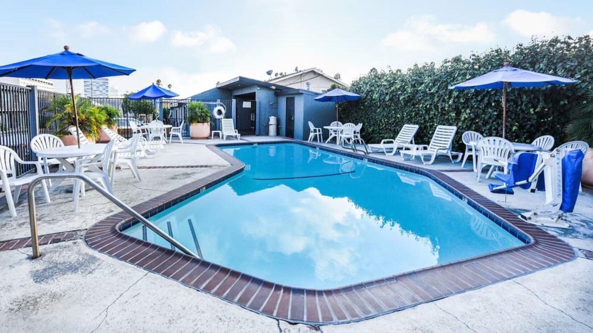 Outdoor pool with lounge area at Travelodge LAX By Wyndham.
