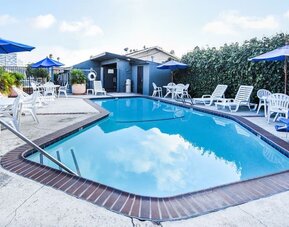 Outdoor pool with lounge area at Travelodge LAX By Wyndham.