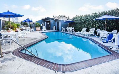 Outdoor pool with lounge area at Travelodge LAX By Wyndham.