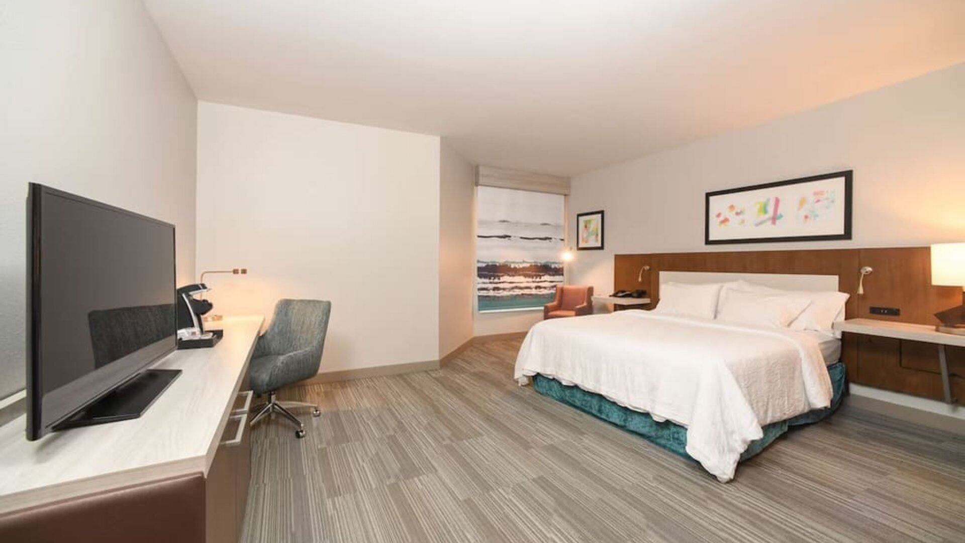 Spacious day use room with king bed, workdesk, TV screen and private bathroom at Hilton Garden Inn Cincinnati Midtown.