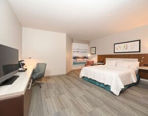 Spacious day use room with king bed, workdesk, TV screen and private bathroom at Hilton Garden Inn Cincinnati Midtown.