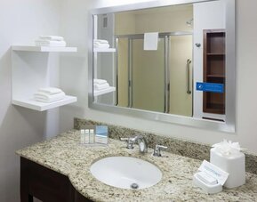 Private guest bathroom with shower and free toiletries at Hampton Inn Los Angeles-Orange County-Cypress.