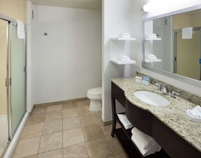 Private guest bathroom with shower and free toiletries at Hampton Inn Los Angeles-Orange County-Cypress.