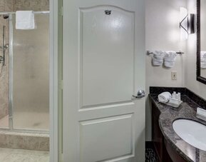 Private guest bathroom with shower and free toiletries at Homewood Suites By Hilton Agoura Hills.