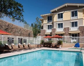 Outdoor pool with lounge chairs at Homewood Suites By Hilton Agoura Hills.
