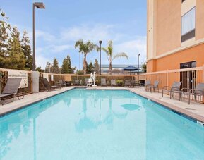 Outdoor pool with lounge chairs at Hampton Inn & Suites Clovis-Airport North.