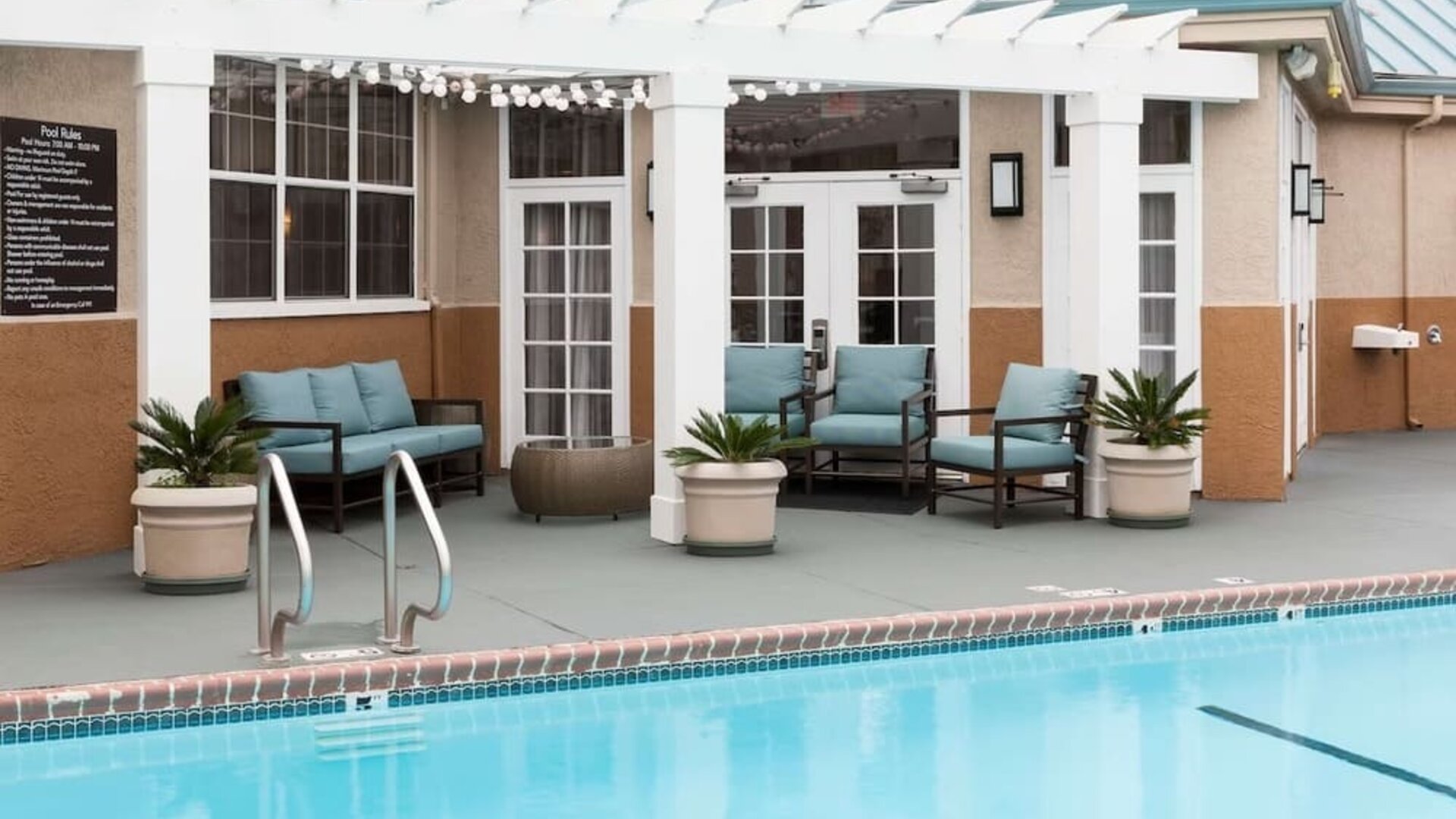 Outdoor pool with lounge chairs at Homewood Suites By Hilton San Jose Airport-Silicon Valley.