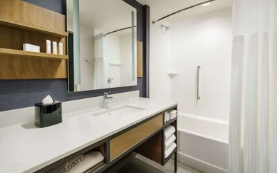 Private guest bathroom with combined shower and tub at Hilton Garden Inn Sunnyvale.