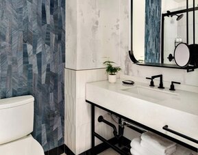 Private guest bathroom with shower and free toiletries at Kimpton Theta New York - Times Square.