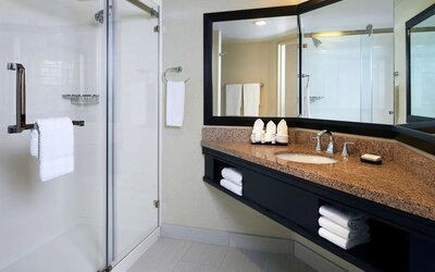 Private guest bathroom with shower and free toiletries at Embassy Suites By Hilton Los Angeles-Intl Airport North.