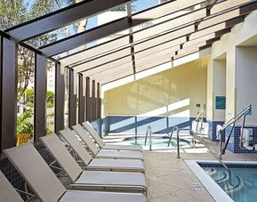 Indoor pool with jacuzzi and lounge area at Embassy Suites By Hilton Los Angeles-Intl Airport North.