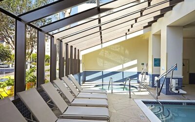 Indoor pool with jacuzzi and lounge area at Embassy Suites By Hilton Los Angeles-Intl Airport North.