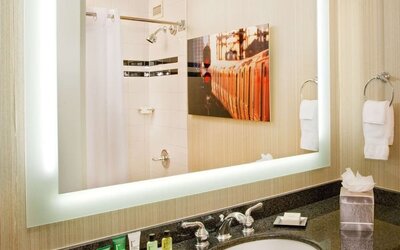 Private guest bathroom with shower and free toiletries at Hilton Newark Airport.