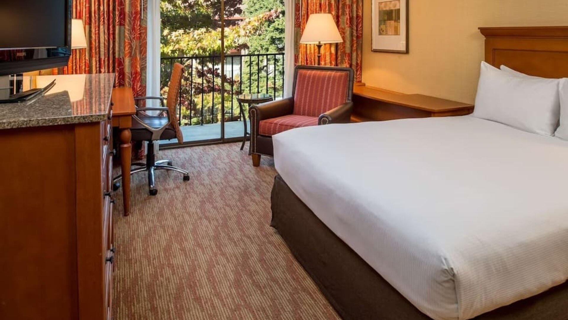 Comfortable king bedroom with balcony at the DoubleTree by Hilton Seattle Airport.