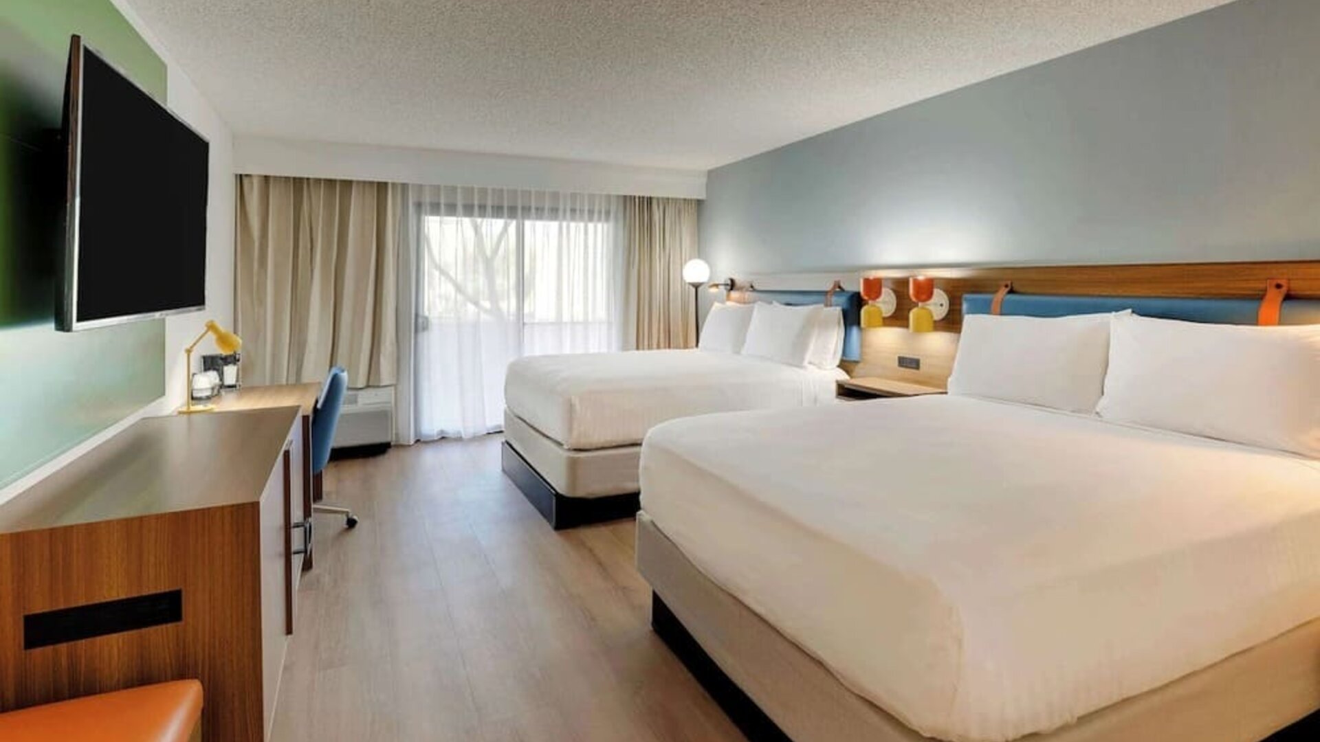 Day use twin room with work desk, TV screen and floor to ceiling windows at Sonesta Select Scottsdale At Mayo Clinic Campus.