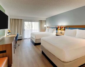 Day use twin room with work desk, TV screen and floor to ceiling windows at Sonesta Select Scottsdale At Mayo Clinic Campus.