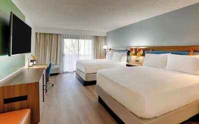 Day use twin room with work desk, TV screen and floor to ceiling windows at Sonesta Select Scottsdale At Mayo Clinic Campus.