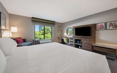 Day use room with work desk and sofa at Hampton Inn Detroit Southfield.
