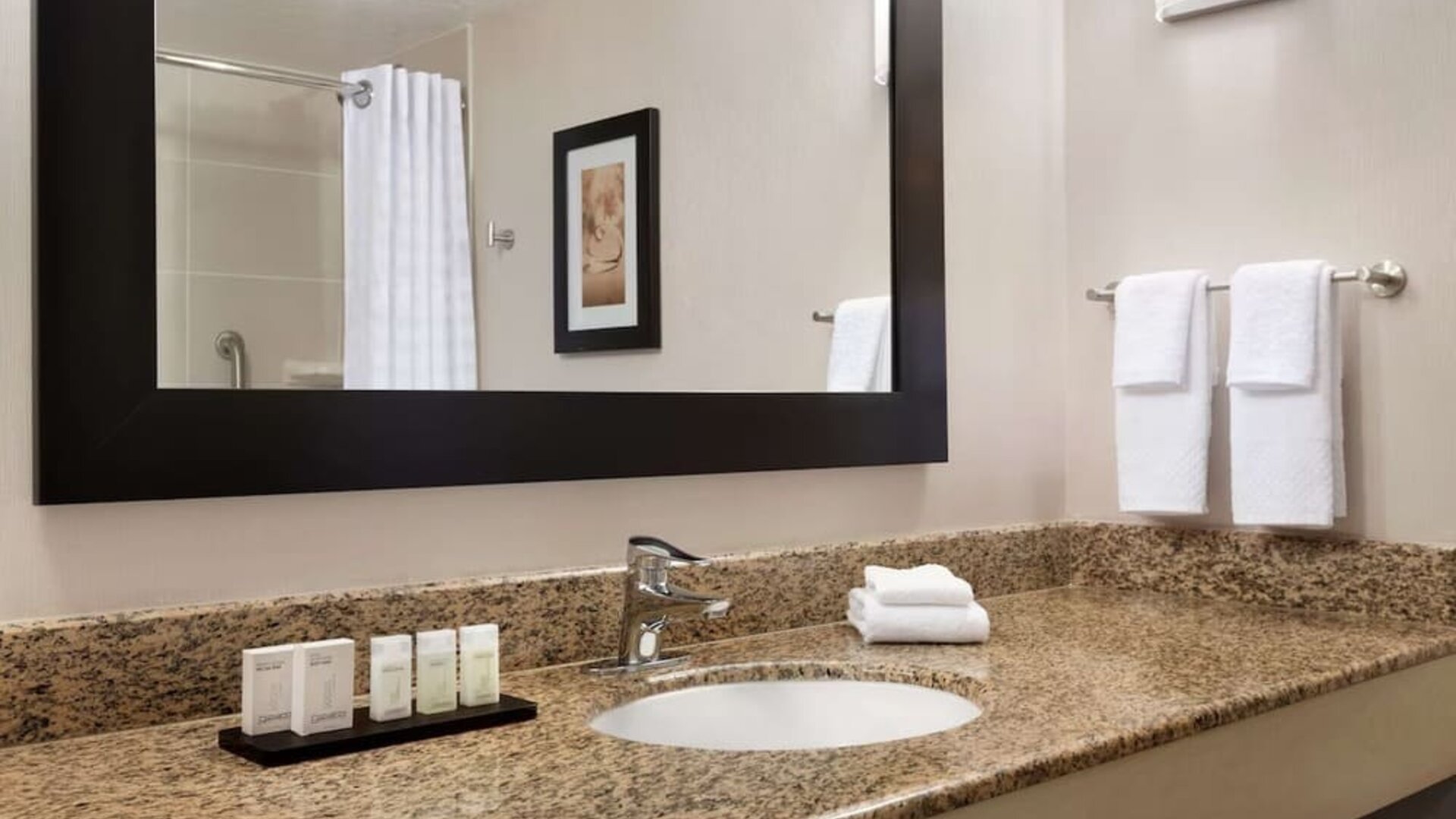 Private guest bathroom with shower and free toiletries at Embassy Suites By Hilton Convention Center Las Vegas.