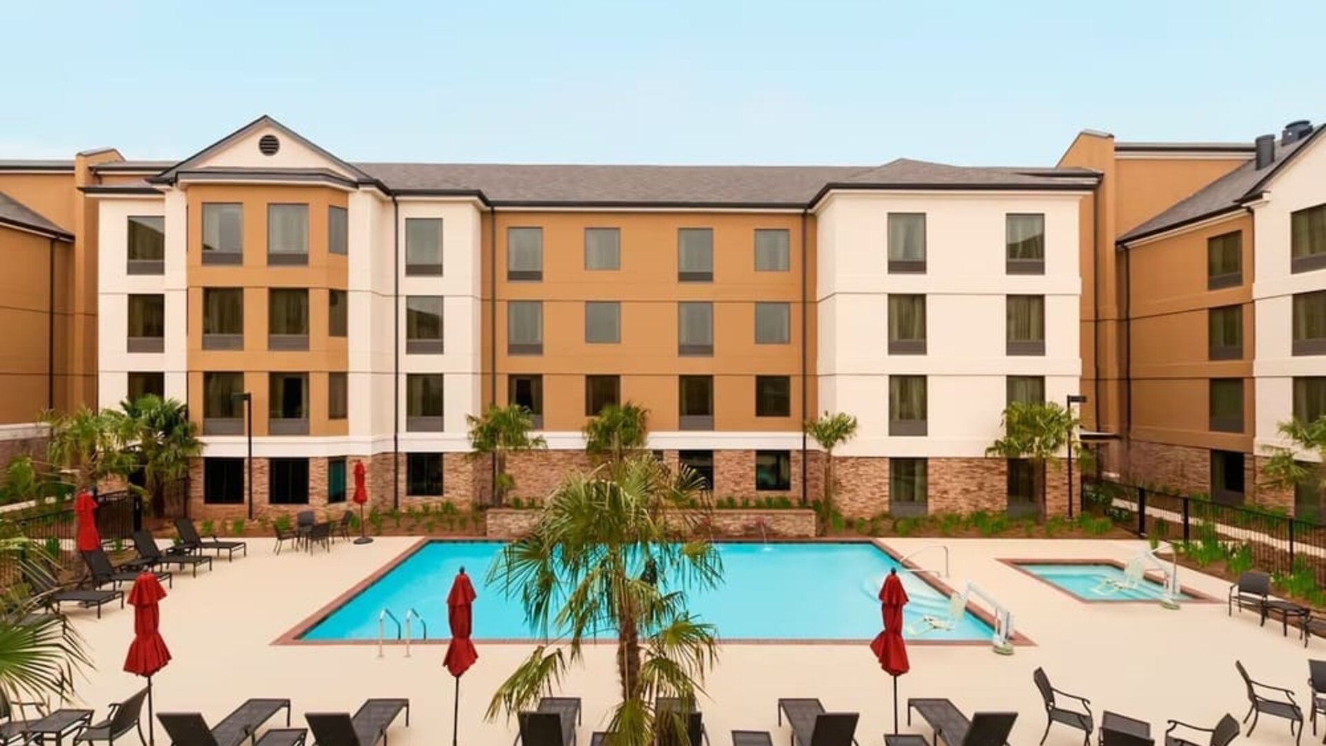 Outdoor pool with lounge chairs at Homewood Suites By Hilton Shreveport / Bossier City, LA.