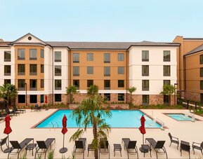 Outdoor pool with lounge chairs at Homewood Suites By Hilton Shreveport / Bossier City, LA.