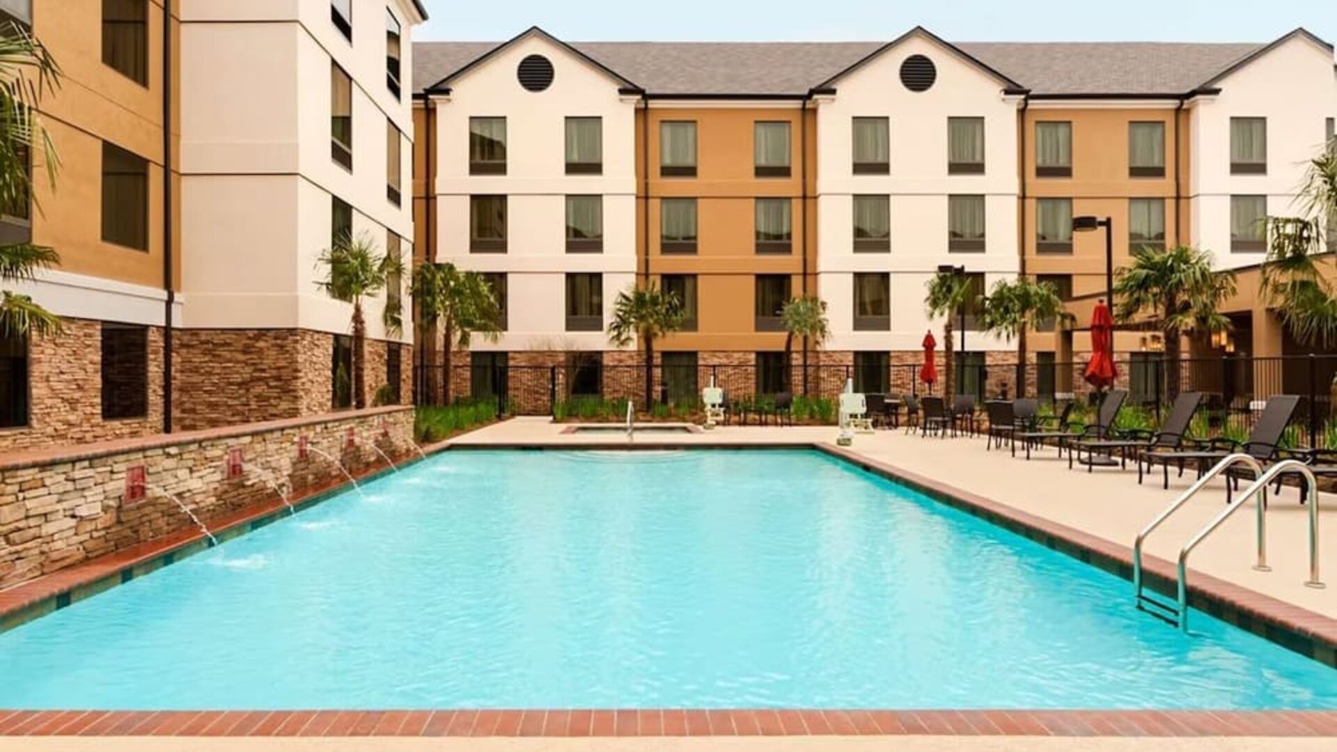 Outdoor pool with lounge seating at Homewood Suites By Hilton Shreveport / Bossier City, LA.