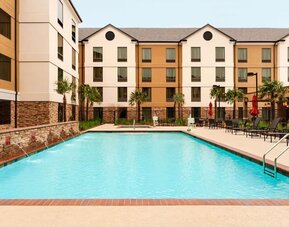 Outdoor pool with lounge seating at Homewood Suites By Hilton Shreveport / Bossier City, LA.