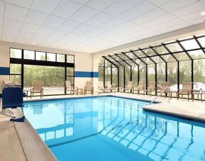 Indoor pool with lounge chairs at DoubleTree By Hilton Hartford - Bradley Airport.