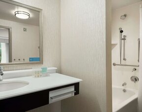 Private guest bathroom with combined shower and tub at Hampton Inn & Suites Rosemont Chicago O'Hare.