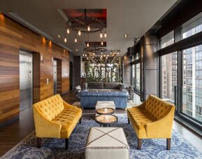 Lounge and coworking area beside elevators at Royalton Park Avenue.