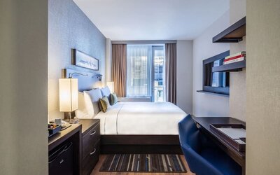 Day use room with work desk and balcony at The Bernic Hotel New York City, Tapestry Collection By Hilton.
