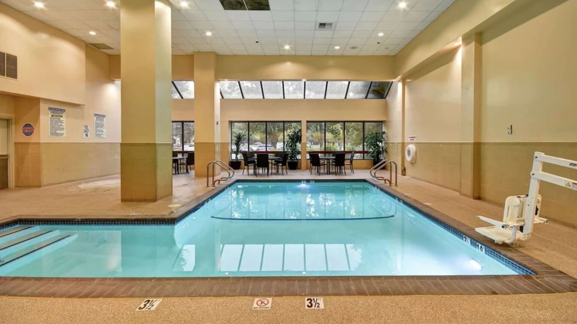 Relaxing indoor pool with seating area at Embassy Suites By Hilton Santa Clara Silicon Valley.