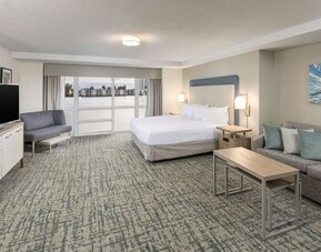 Spacious day use room with sofa and a view of the Blue Lagoon at Homewood Suites By Hilton Miami Airport-Blue Lagoon.