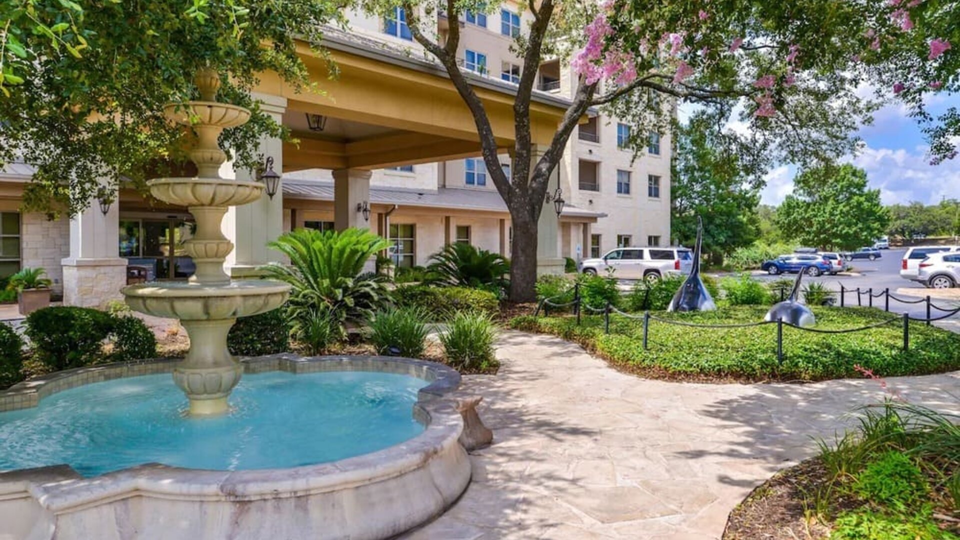 Hotel facade and the parking area at Hilton San Antonio Hill Country.