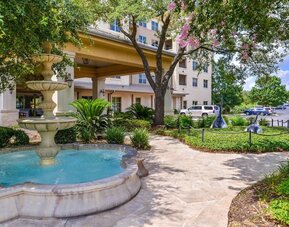 Hotel facade and the parking area at Hilton San Antonio Hill Country.