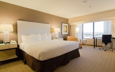 Delux king room with work desk and natural light at Hilton Los Angeles Airport.