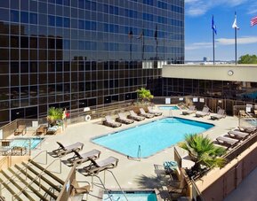 Stunning outdoor pool surrounded by loungers at Hilton Los Angeles Airport.