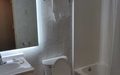 Guest bathroom with shower and tub at Hotel Key.