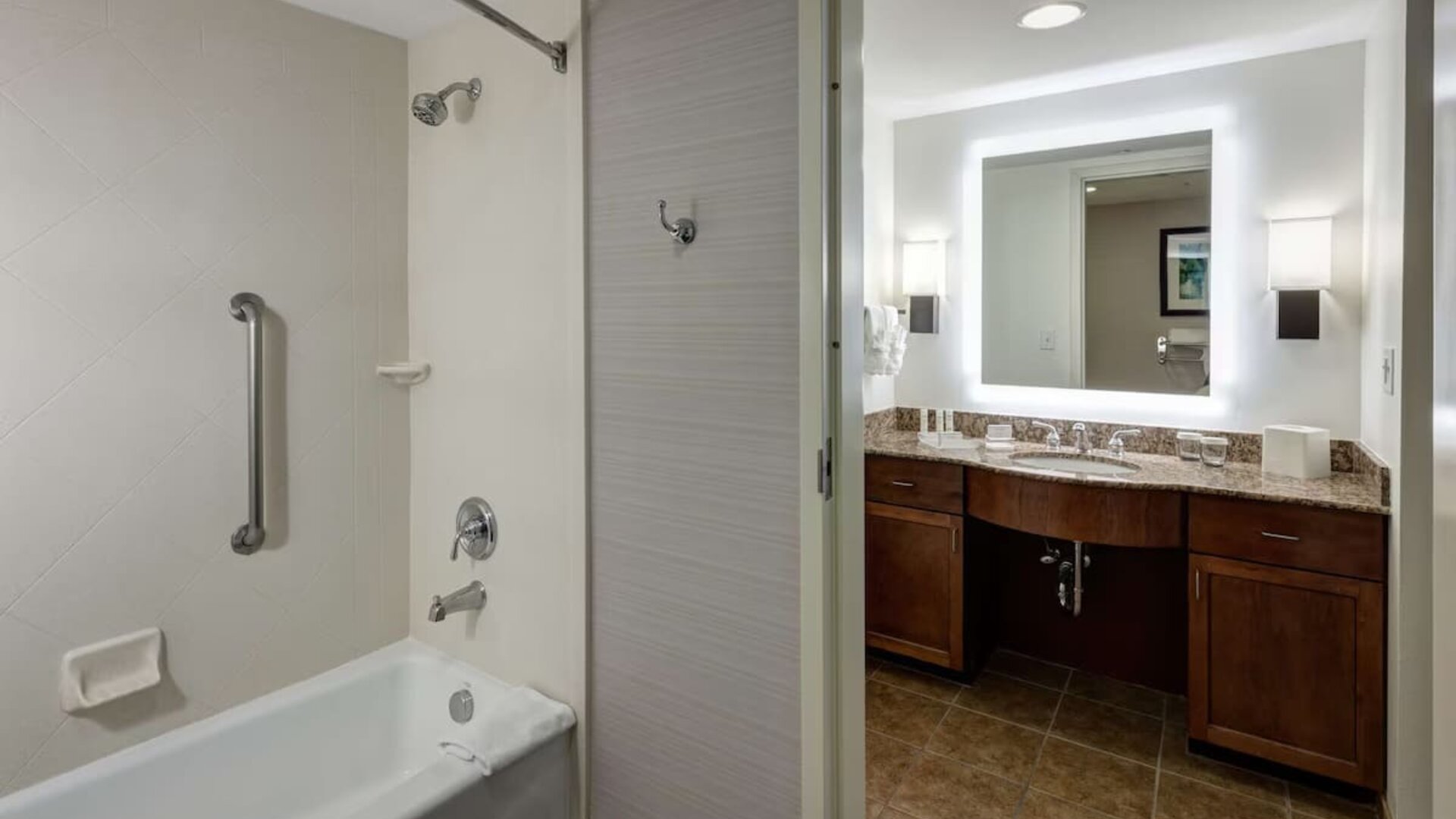Private guest bathroom with combined shower and tub at Homewood Suites By Hilton Denton.